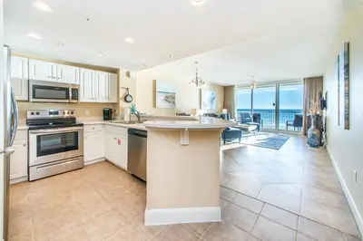 a kitchen with white cabinets and a view of the ocean at Majestic Beach Towers 2-403 in Panama City Beach