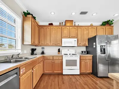a kitchen with wooden cabinets and stainless steel appliances at Ocean Spray in Panama City