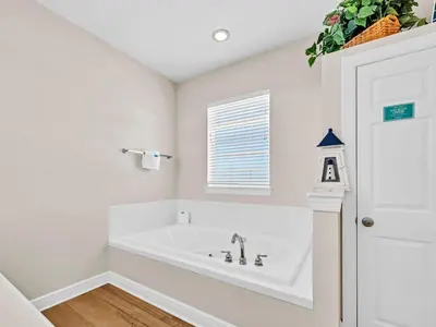 a white bathroom with a tub and a window at Ocean Spray in Panama City