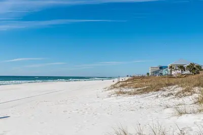 a sandy beach with a house and the ocean at Ocean Spray in Panama City