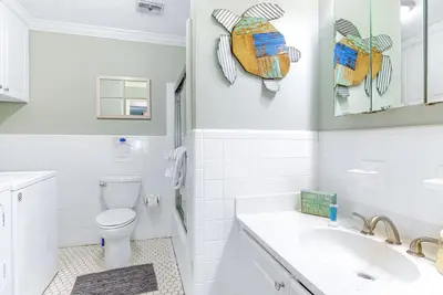 a white bathroom with a toilet and a sink at Bay Shore in Panama City Beach