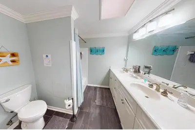 a white bathroom with a toilet and a sink at Bay Shore in Panama City Beach