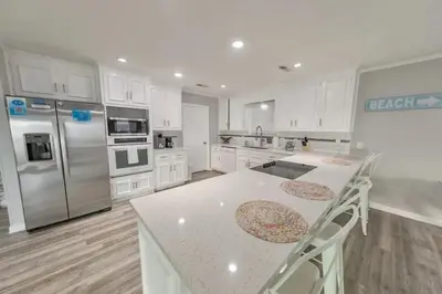 a kitchen with white cabinets and a white counter top at Sandy Feet Retreat in Panama City Beach