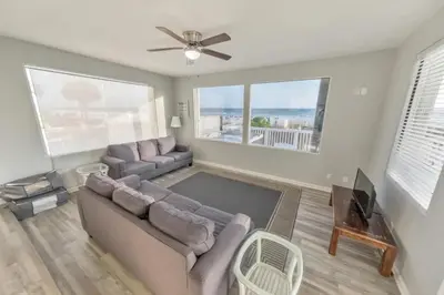 a living room with a couch and a tv at Sandy Feet Retreat in Panama City Beach
