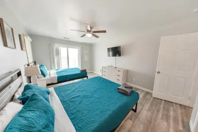 a bedroom with a large bed and a ceiling fan at Sandy Feet Retreat in Panama City Beach