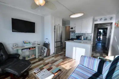 a living room with a couch and a kitchen at Sea Glass Villa in Panama City Beach