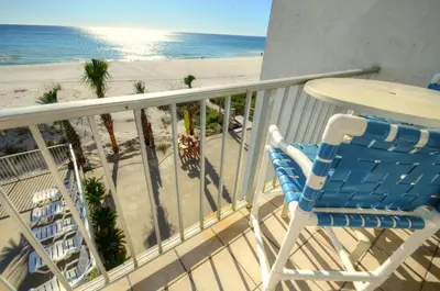 a balcony with a table and chairs and the beach at Sea Glass Villa in Panama City Beach