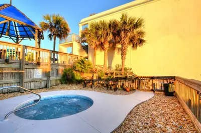 a hot tub in a yard next to a house at Sea Glass Villa in Panama City Beach