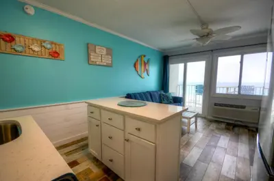 a kitchen with blue walls and a ceiling fan at Sea Glass Villa in Panama City Beach