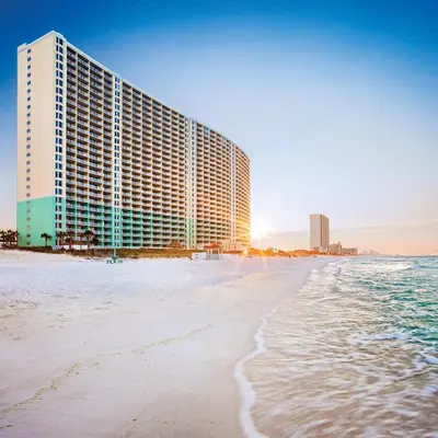 a building on the beach next to the ocean at Club Wyndham Panama City Beach in Panama City Beach