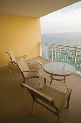 four chairs and a table on a balcony with the ocean at Club Wyndham Panama City Beach in Panama City Beach