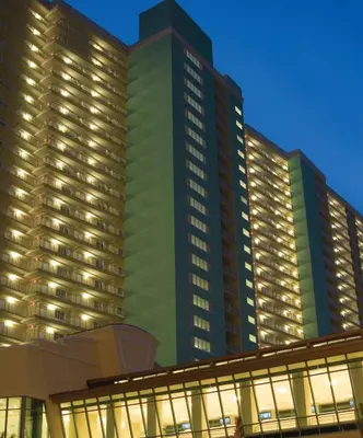 a tall green building with lights in front of it at Club Wyndham Panama City Beach in Panama City Beach