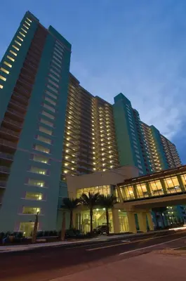 a large building with palm trees in front of it at Club Wyndham Panama City Beach in Panama City Beach