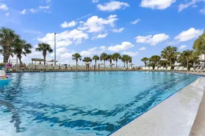 a large swimming pool with palm trees in the background at The Summit 616 in Panama City Beach