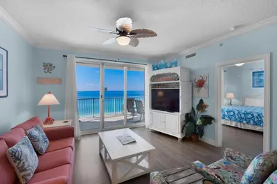 a living room with a couch and a television and a bedroom at Twin Palms 1201 in Panama City Beach