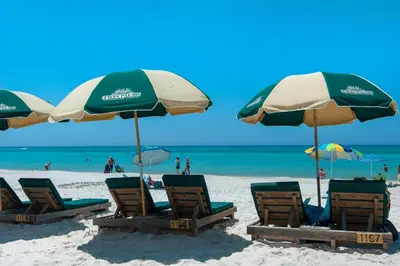 a group of chairs and umbrellas on a beach at Twin Palms 1201 in Panama City Beach