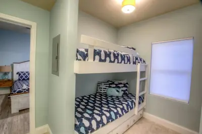 a bedroom with two bunk beds and a window at Laketown Wharf 429 By Aneliya in Panama City Beach