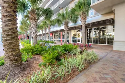 a building with palm trees and plants in a courtyard at Laketown Wharf 429 By Aneliya in Panama City Beach