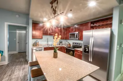 a kitchen with wooden cabinets and stainless steel refrigerator at Laketown Wharf 429 By Aneliya in Panama City Beach