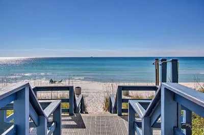 a blue boardwalk to the beach with the ocean at Gulf Coast Getaway with Balcony and Resort Amenities! in Panama City Beach