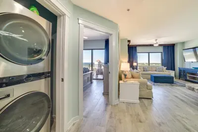 a living room with a view of a living room at Breezy Panama City Beach Condo with Private Balcony! in Panama City Beach