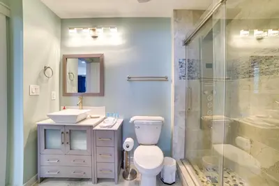 a bathroom with a toilet and a sink and a shower at Breezy Panama City Beach Condo with Private Balcony! in Panama City Beach
