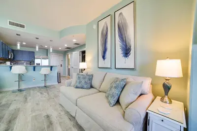 a living room with a couch and a table at Breezy Panama City Beach Condo with Private Balcony! in Panama City Beach