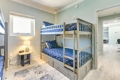 a bedroom with two bunk beds and a desk at Panama City Beachfront Condo with Breathtaking Views in Panama City Beach