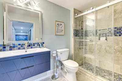 a bathroom with a toilet and a glass shower at Panama City Beachfront Condo with Breathtaking Views in Panama City Beach