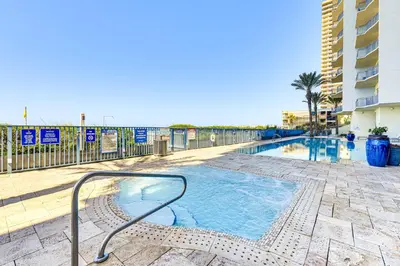 a swimming pool with a metal rail next to a building at Panama City Beachfront Condo with Breathtaking Views in Panama City Beach