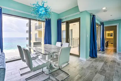 a dining room with a table and chairs and the ocean at Chic Panama City Beach Condo with Pool and Gulf Views in Panama City Beach