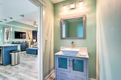 a bathroom with a sink and a mirror at Chic Panama City Beach Condo with Pool and Gulf Views in Panama City Beach