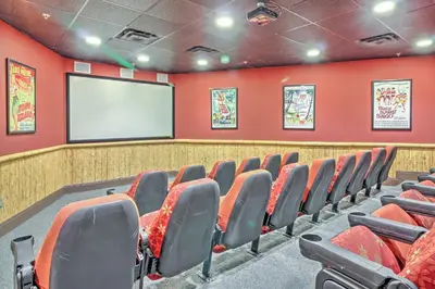 a cinema room with red walls and a screen at Chic Panama City Beach Condo with Pool and Gulf Views in Panama City Beach