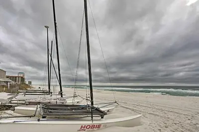a group of sailboats sitting on the beach at Convenient PCB Condo with Pool Access Walk to Beach in Panama City Beach