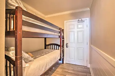 a bedroom with two bunk beds and a door at Oceanfront PCB Condo with Balcony and Pool Access! in Panama City Beach