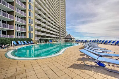 a swimming pool in front of a large building at Oceanfront PCB Condo with Balcony and Pool Access! in Panama City Beach