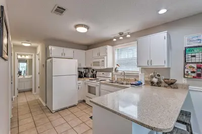 a kitchen with white cabinets and a white refrigerator at Seagrove Beach Condo with Pool Access Walk to Beach in Seagrove Beach