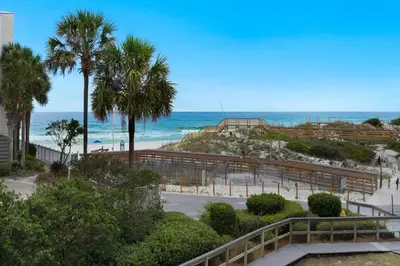 a view of a beach with palm trees and the ocean at Seagrove Beach Condo with Pool Access Walk to Beach in Seagrove Beach