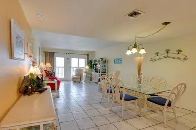 a dining room with a glass table and chairs at Panama City Beach Retreat with Pool and Ocean Views! in Panama City Beach