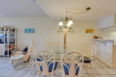 a dining room with a glass table and chairs at Panama City Beach Retreat with Pool and Ocean Views! in Panama City Beach