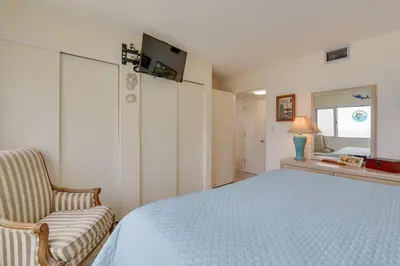 a bedroom with a bed and a chair and a window at Panama City Beach Retreat with Pool and Ocean Views! in Panama City Beach