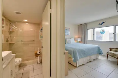 a bedroom with a bed and a bathroom with a shower at Panama City Beach Retreat with Pool and Ocean Views! in Panama City Beach