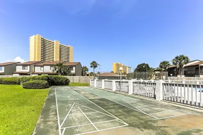 a tennis court in a yard with houses at PCB Condo with Pool and Grill Access - Walk to Beach! in Panama City Beach