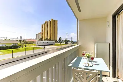 a balcony with a table and a view of a building at PCB Condo with Pool and Grill Access - Walk to Beach! in Panama City Beach