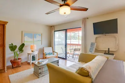 a living room with a couch and a flat screen tv at Cute PCB Condo by Lake Powell with Pool Access! in Panama City Beach