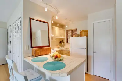 a kitchen with a table and a white refrigerator at Cute PCB Condo by Lake Powell with Pool Access! in Panama City Beach
