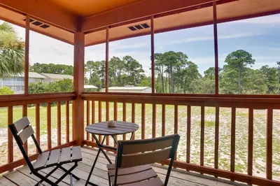 a porch with a table and two chairs and a table at Cute PCB Condo by Lake Powell with Pool Access! in Panama City Beach