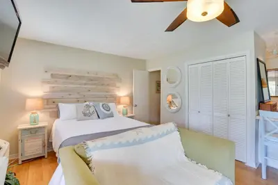 a bedroom with a large white bed and a couch at Cute PCB Condo by Lake Powell with Pool Access! in Panama City Beach