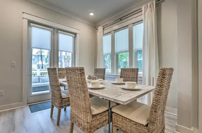 a dining room with a table and chairs and windows at Always Saturday Prominence Resort Townhome! in Inlet Beach