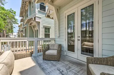 a front porch with a chair and a couch at Always Saturday Prominence Resort Townhome! in Inlet Beach